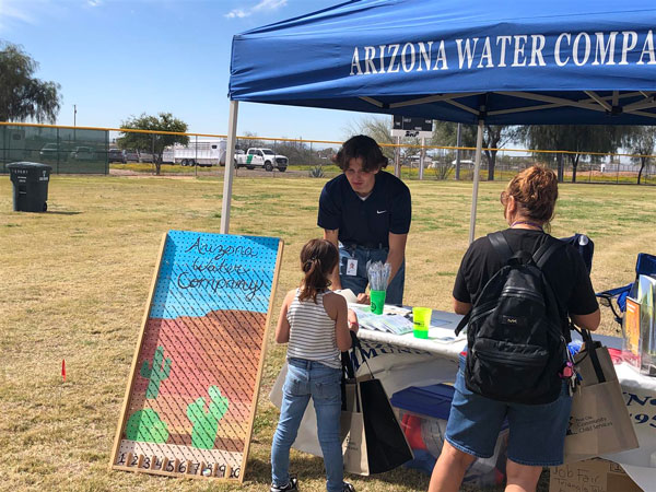 AWC staff at a booth event encouraging kids to conserve water.
